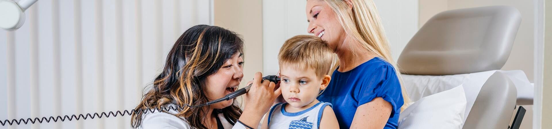Doctor working with child as mother looks on